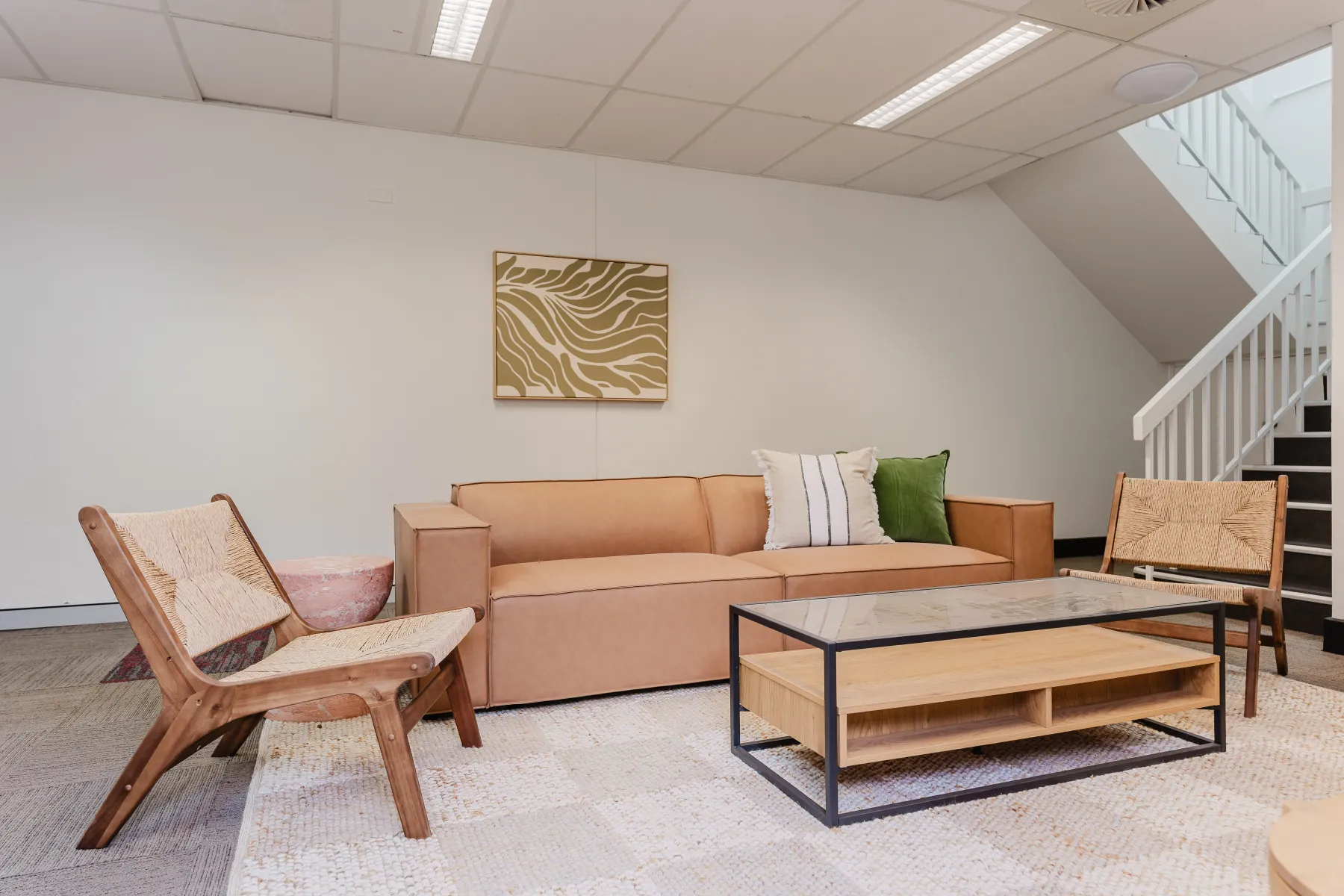A relaxed lounge with a tan sofa and natural textures at Sareh Balmain
